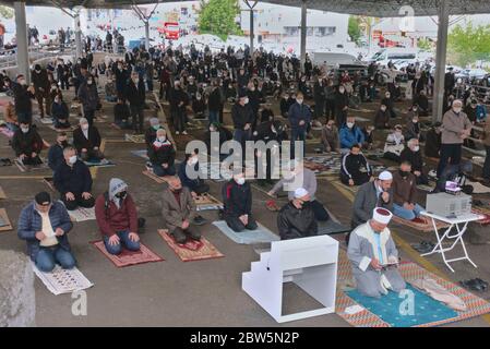 Ankara/Turchia - 29/05/2020 Ankara/Turchia - 29/05/2020: Imam guida il gruppo di musulmani a distanza sociale che siedono sul tappeto di preghiera nella prima Jum Foto Stock