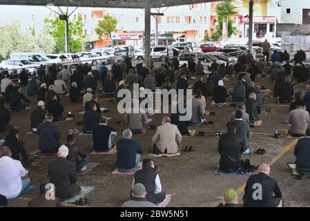 Ankara/Turchia - 29/05/2020 Ankara/Turchia - 29/05/2020: Imam guida il gruppo di musulmani a distanza sociale seduti sul tappeto di preghiera nel primo Ven Foto Stock