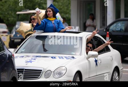 Arlington, Stati Uniti. 29 maggio 2020. Un laureato scatta una foto dal tetto durante la parata di laurea della Marymount University che celebra la classe del 2020, ad Arlington, Virginia, il 29 maggio 2020. La scuola aiuta una parata di laurea a distanza sociale dovuta al Coronavirus COVID-19. Foto di Kevin Dietsch/UPI Credit: UPI/Alamy Live News Foto Stock