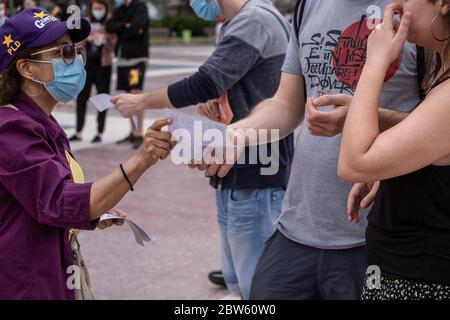 Barcellona, Spagna. 29 maggio 2020. Un collaboratore che distribuisce fogli informativi durante l'assemblea.dopo mesi di reclusione, l'Unione Llogateres (Unione inquilini) ha tenuto la sua prima assemblea pubblica a Plaza Catalunya. I temi principali della riunione erano di negoziare i prezzi di affitto ed evitare sfratti così come di entrare in contatto con i nuovi inquilini che hanno difficoltà a pagare l'affitto sui loro appartamenti. Credit: SOPA Images Limited/Alamy Live News Foto Stock