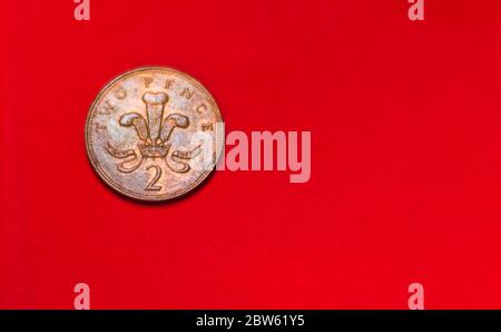 British Coin 2 pence (2001) isolato su sfondo rosso con sfocatura e spazio per il testo della copia. Lato anteriore di due gettoni pence. Monete collezionisti wolrdwide. Foto Stock