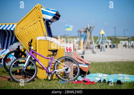 Tossens, Germania. 29 maggio 2020. Una bicicletta si appoggia su una sedia da spiaggia blu su una sedia gialla presso il Friesenstrand nel quartiere di Wesermarsch. A Whitsun, numerosi vacanzieri sono attesi sulla costa bassa Sassonia, sulle isole e altrove. Credit: Hauke-Christian Dittrich/dpa/Alamy Live News Foto Stock