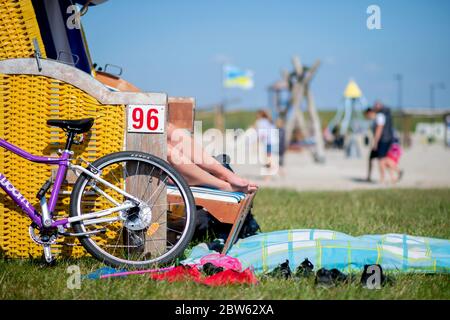 Tossens, Germania. 29 maggio 2020. Una bicicletta si appoggia su una sedia da spiaggia blu su una sedia gialla presso il Friesenstrand nel quartiere di Wesermarsch. A Whitsun, numerosi vacanzieri sono attesi sulla costa bassa Sassonia, sulle isole e altrove. Credit: Hauke-Christian Dittrich/dpa/Alamy Live News Foto Stock