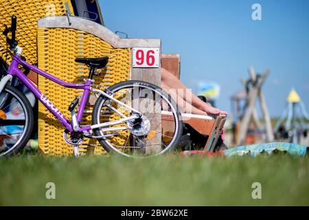 Tossens, Germania. 29 maggio 2020. Una bicicletta si appoggia su una sedia da spiaggia blu su una sedia gialla presso il Friesenstrand nel quartiere di Wesermarsch. A Whitsun, numerosi vacanzieri sono attesi sulla costa bassa Sassonia, sulle isole e altrove. Credit: Hauke-Christian Dittrich/dpa/Alamy Live News Foto Stock