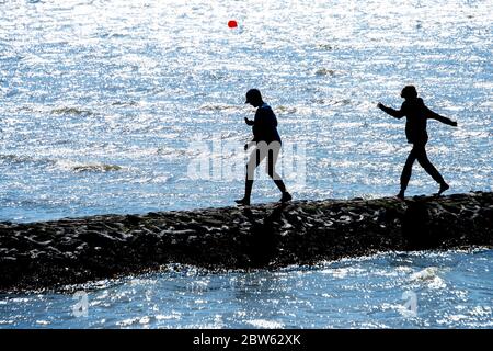 Tossens, Germania. 29 maggio 2020. Due ragazzi corrono su un groyne al Friesenstrand nel distretto di Wesermarsch. A Whitsun, numerosi vacanzieri sono attesi sulla costa bassa Sassonia, sulle isole e altrove. Credit: Hauke-Christian Dittrich/dpa/Alamy Live News Foto Stock