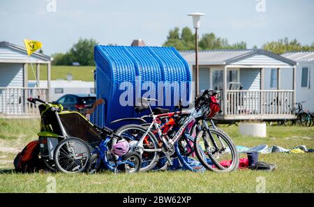 Tossens, Germania. 29 maggio 2020. Le biciclette di una famiglia sono appoggiate su una sedia blu sulla spiaggia di Friesenstrand, nel quartiere di Wesermarsch. A Whitsuntide, numerosi turisti sono attesi sulla costa della bassa Sassonia, le isole e altrove. Credit: Hauke-Christian Dittrich/dpa/Alamy Live News Foto Stock