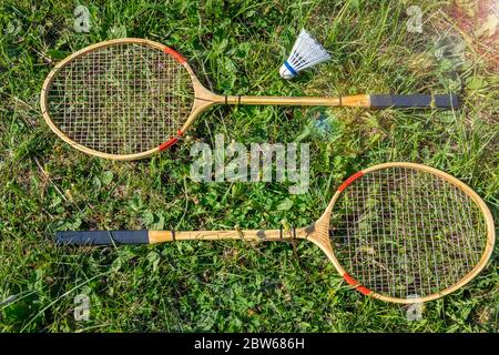 un set di racchette e un shuttleock per giocare a badminton si trovano su un prato verde Foto Stock