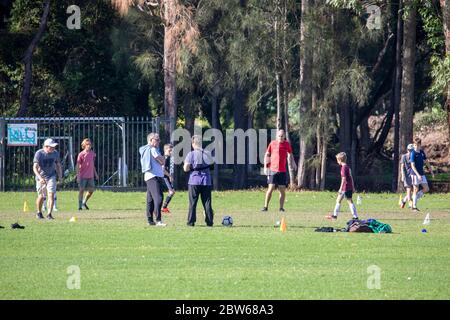 Uomini e ragazzi che giocano a calcio in un parco di Sydney mentre la ripresa dalla pandemia continua in Australia Foto Stock