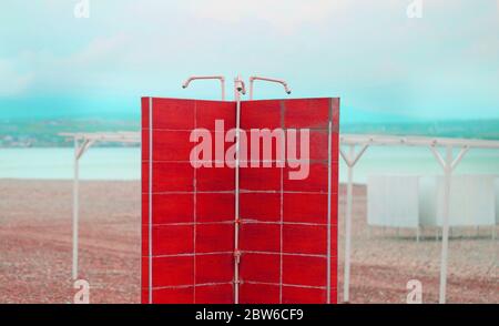 Foto di una bellissima spiaggia retrò con docce e cabine sulla costa del mare Foto Stock