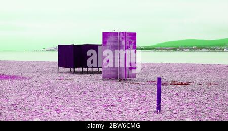 Foto di una bellissima spiaggia retrò con docce e cabine sulla costa del mare Foto Stock