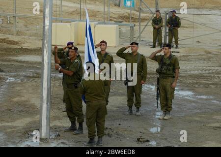 Gli ufficiali militari israeliani salutano l'abbassamento di una bandiera israeliana all'incrocio di Kissufim, che ha portato al blocco di insediamenti israeliani nella striscia di Gaza l'ultimo giorno della presenza militare israeliana nell'area palestinese, completando un ritiro dal territorio dopo 38 anni di occupazione. Israele meridionale Foto Stock