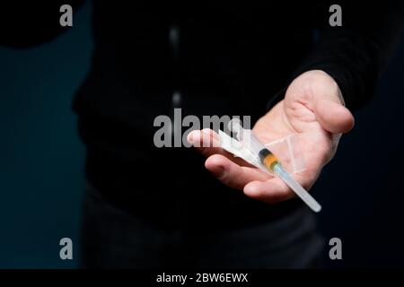 L'uomo tiene fuori la sua palma aperta con le droghe, offrendo una dose Foto Stock