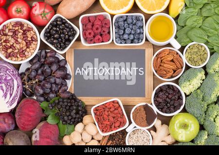 Fonti alimentari di antiossidanti naturali come frutta, verdura, frutta a guscio e cacao in polvere. Gli antiossidanti neutralizzano i radicali liberi Foto Stock