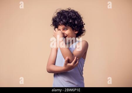 Un ritratto di ragazzo con capelli ricci naso vicino a causa di cattivo odore. Concetto di bambini ed emozioni Foto Stock