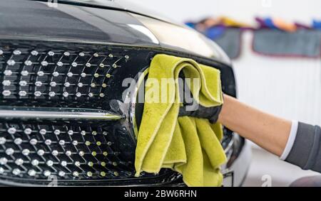 lucidare il corpo di auto di lusso con l'aiuto di un panno in microfibra per una perfetta brillantezza Foto Stock