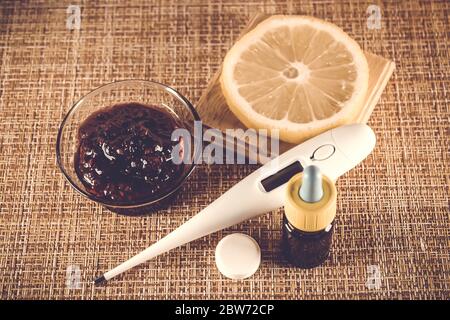 Trattamento di raffreddori e influenza. Vari farmaci, termometro, pillole fredde, spray alla gola, gocce nasali, limone su sfondo marrone. Trattamento dell'afflusso Foto Stock