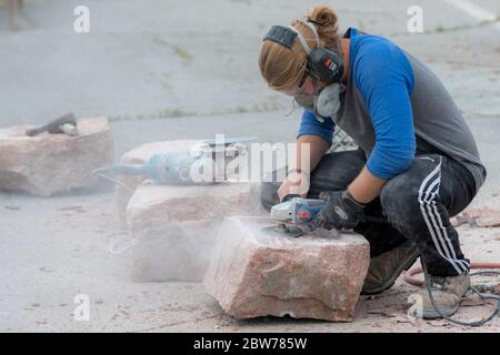 San Giovanni, New Brunswick, Canada - 2 settembre 2018: Uno scultore usa gli attrezzi di potere per modellare la pietra. Foto Stock