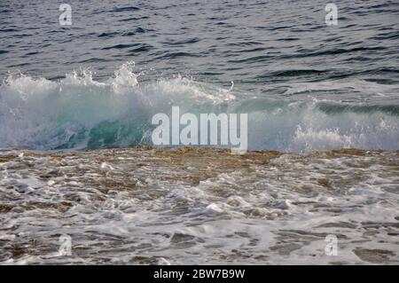 Onda che colpisce le rocce. Onde marine selvagge a tempo tempestoso. Foto Stock