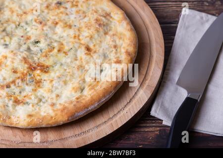 Torta Ossetiana con formaggio ed erbe (aneto, prezzemolo, scalione). Cottura tradizionale Ossezia. Foto Stock