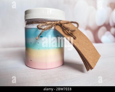 Bottiglia con un prodotto cosmetico di colore arcobaleno. Modello per l'industria cosmetica. Foto Stock