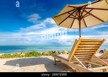 Bellissima spiaggia. Sedie sulla spiaggia di sabbia vicino al mare. Concetto di vacanza estiva e vacanza. Paesaggio tropicale della spiaggia. Vacanza esotica e estate Foto Stock