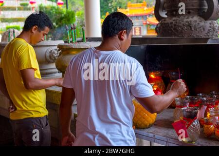 Uomini che bruciano incenso a Kek Lok si, Penang, Malesia Foto Stock