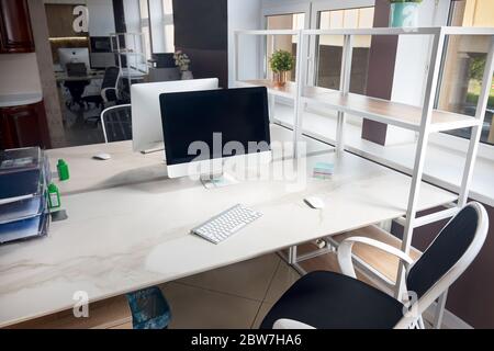GRODNO, BIELORUSSIA - MAGGIO 2020: Due iMac Apple in un tavolo da ufficio con display vuoti con piano in gres, moderno luogo di lavoro di ufficio alla moda in loft sty Foto Stock