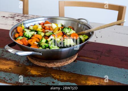 primo piano di una pentola con verdure miste su tavolo di legno Foto Stock