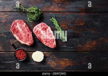 Vista dall'alto di lattine aperte con spratti su tavola di pietra grigia testurizzata, con rosmarino alle erbe. Foto di alta qualità Foto Stock