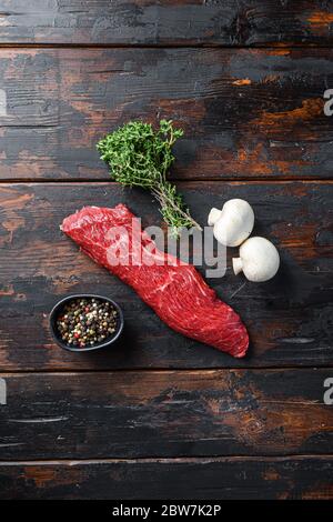 Bistecca a tre punte con timo di condimenti fresco, per barbecue su sfondo di legno, vista dall'alto. Foto Stock