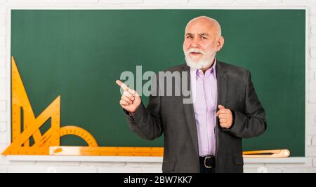 guarda e impara. torna a scuola. Strumenti grafici matematici. Lezione di trigonometria in classe. Scopri qui. Insegnante di alto livello usa strumenti matematici. Docente con bearded uomo spiega la geometria sulla lavagna. Foto Stock