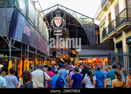 BARCELLONA, SPAGNA - 29 GIUGNO 2017: Negozi di persone a Barcellona mercato Mercat de Sant Josep de la Boqueria, un grande mercato pubblico e un punto di riferimento turistico Foto Stock