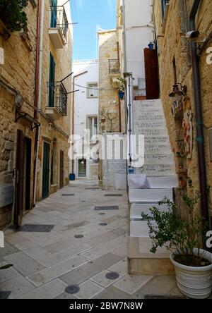 POLIGNANO A MARE, ITALIA - 29 MARZO 2018: Strada stretta tipica con scale decorate che conducono ad un appartamento nel centro di Polignano a Mare, Pugli Foto Stock