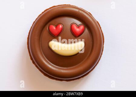 M&S latte cioccolato emozioni - Metti un sorriso sul viso cioccolato rimosso dalla confezione isolato su sfondo bianco - occhi cuore rosso amore emoticon emoji Foto Stock