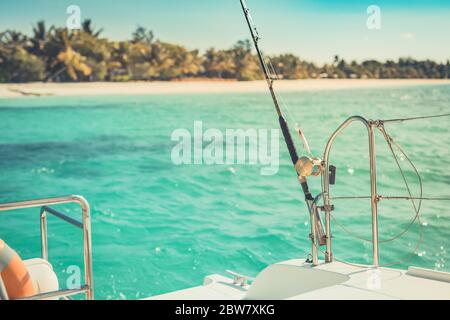 Primo piano di una mulinello da pesca sulla barca, isola tropicale mare con tempo soleggiato. Sport esotico e attività ricreative Foto Stock