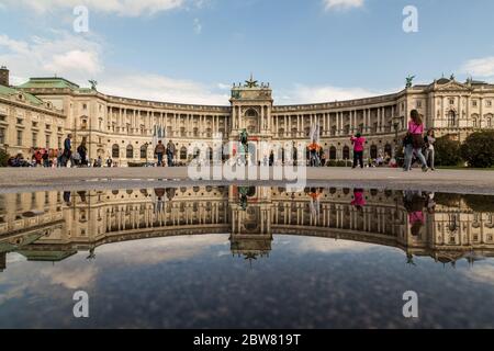 VIENNA, AUSTRIA - 12 GIUGNO 2016: L'esterno della Biblioteca Nazionale austriaca durante il giorno. L'edificio si può vedere riflesso in un pozze. Persone Foto Stock