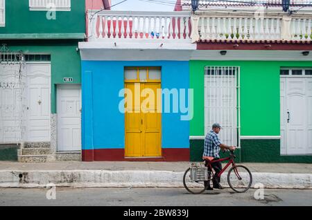 Un uomo che cavalcano una bicicletta per le strade di Trinidad a Cuba Foto Stock