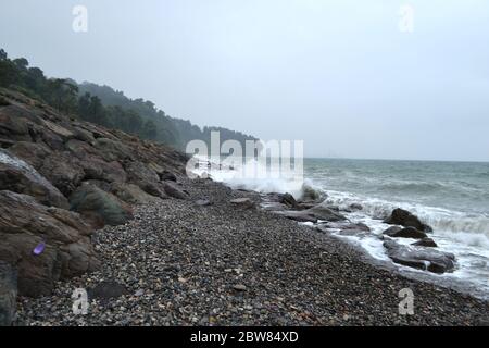 Tempesta sul mare blu onde che si schiantano vicino a una costa rocciosa Batumi Foto Stock