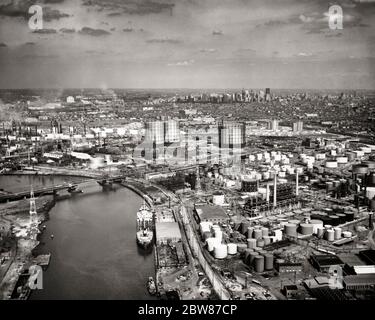 VISTA AEREA DELLO SKYLINE DEGLI ANNI '50 DELLE RAFFINERIE DI PETROLIO LUNGO IL CENTRO CITTÀ DEL FIUME SCHUYLKILL PHILADELPHIA IN BACKGROUND PENNSYLVANIA USA - A868 HAR001 HARS VECCHIO STILE Foto Stock