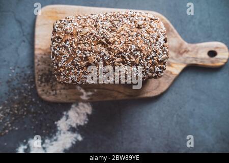 Pane biologico con semi multipli su tavola di legno. Vista dall'alto. Foto Stock