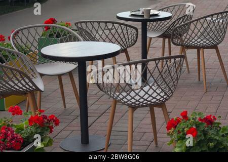 Tavoli e sedie di caffè di strada senza persone. Città Foto Stock