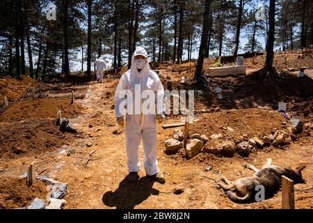 Istanbul, Turchia. 30 maggio 2020. Un operaio di malva che indossa un vestito protettivo è in piedi in un cimitero presso la tomba di una persona che è morto di COVID-19. Credit: Yasin Akgul/dpa/Alamy Live News Foto Stock