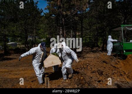 Istanbul, Turchia. 30 maggio 2020. I lavoratori della malva che indossano tute protettive e maschere facciali portano la bara di una persona che è morta di COVID-19 in un cimitero. Credit: Yasin Akgul/dpa/Alamy Live News Foto Stock