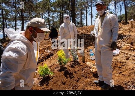 Istanbul, Turchia. 30 maggio 2020. I lavoratori della malva che indossano abiti protettivi e maschere facciali si trovano in un cimitero presso la tomba di una persona che è morta di COVID-19. Credit: Yasin Akgul/dpa/Alamy Live News Foto Stock