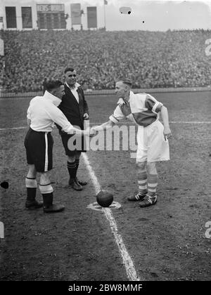 Bromley vs. Erith e Belvedere - finale fa Amatoriale Cup - il capitano di Bromley Billy Holbrook stringe le mani con il capitano di Erith e Belvedere Len Scott. L'arbitro è J.H. Lockton - 23/04/38 al Millwall Football Club Stadium The Den in South Bermondsey, Londra . W T Holbrook ( a sinistra ) il capitano Bromley e L Scott il capitano Erith e Belvedere scuotono le mani prima del gioco . 1938 Foto Stock