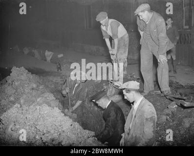 Operai che scavano una trincea per trovare la perdita nella rete idrica dopo un burst pipe in Days Lane , Sidcup . 15 ottobre 1937 Foto Stock