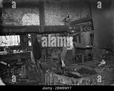 Il fabbro al lavoro nella Forge di Westerham . 1935 Foto Stock