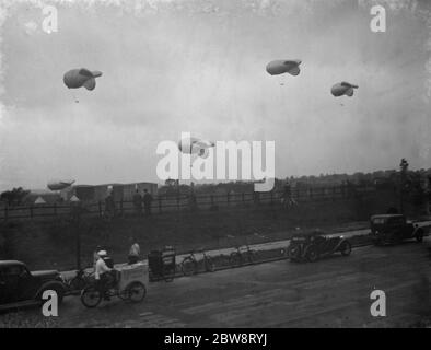 Il Ministro dell'aria Sir Kingsley Wood apre il primo sito di squadroni di palloncini a sbarramento a Kidbrooke , Londra dove palloncini di pratica sono stati portati fuori dagli hangar . Gli spettatori guardano i palloncini da pratica galleggiano dai loro cavi . 6 settembre 1938 Foto Stock