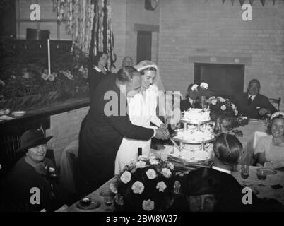 Le nozze di John Topham e di Miss Muriel Haken . Gli sposi hanno tagliato la torta alla colazione di nozze. 1938 Foto Stock