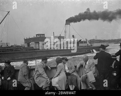 I passangers a bordo di una barca vedano la navigazione del Tamigi a Woolwich , Londra . Un traghetto attraversa il fiume . 1938 Foto Stock